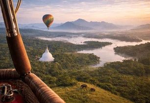 View from a hot air balloon basket over a lake and stupa